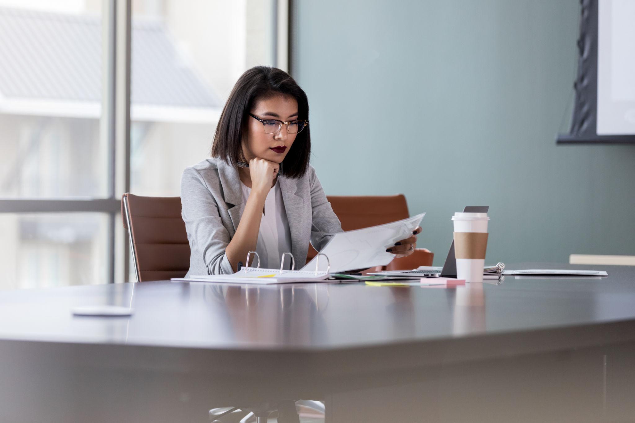 A PrismCX consultant reviewing engagement notes at a conference table